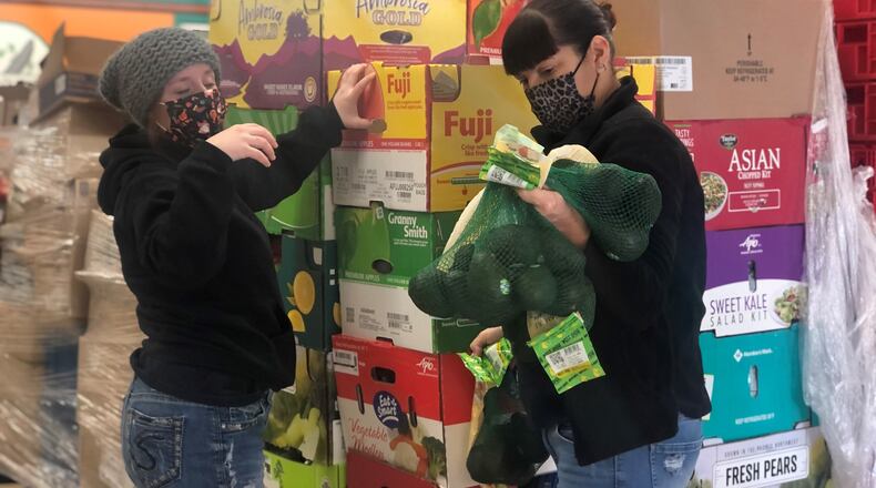 Miami Valley Meals chefs Mac Haynes and Angela Abnett sort and stack produce and other food items. CORNELIUS FROLIK / STAFF