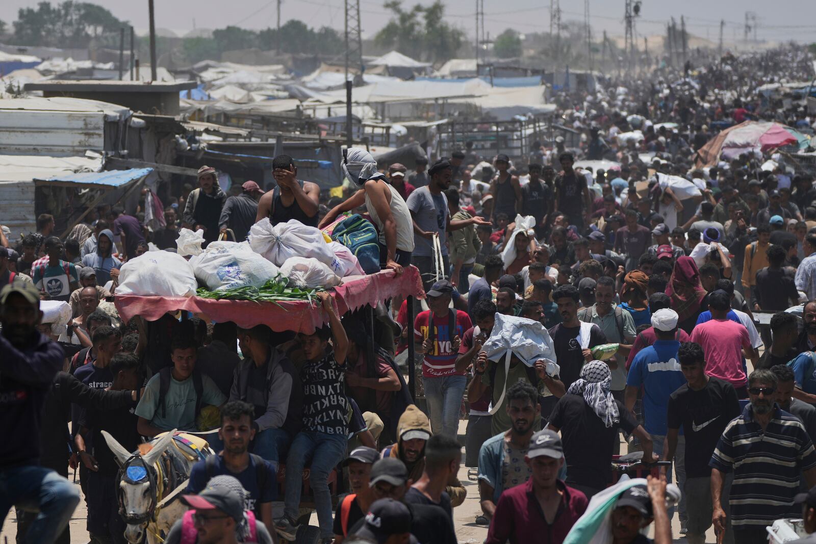 Palestinians carry bags containing food and humanitarian aid packages delivered by the Gaza Humanitarian Foundation, a U.S.-backed organization, in Rafah, southern Gaza Strip, Tuesday, June 10, 2025. (AP Photo/Abdel Kareem Hana)