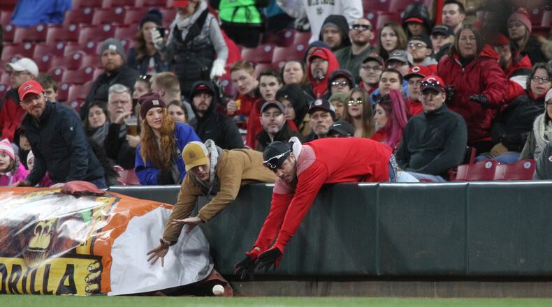 Fans try to catch a foul ball during a game between the Reds and Brewers on Monday, April 1, 2019, at Great American Ball Park in Cincinnati.
