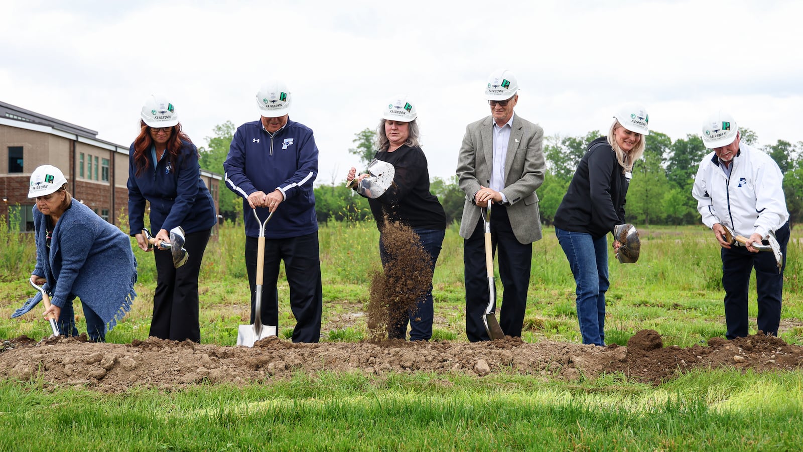 Past and present Fairborn City Schools board of education members participate in a groundbreaking ceremony on Tuesday afternoon on the site where the district's middle school will be constructed. BRYANT BILLING / STAFF
