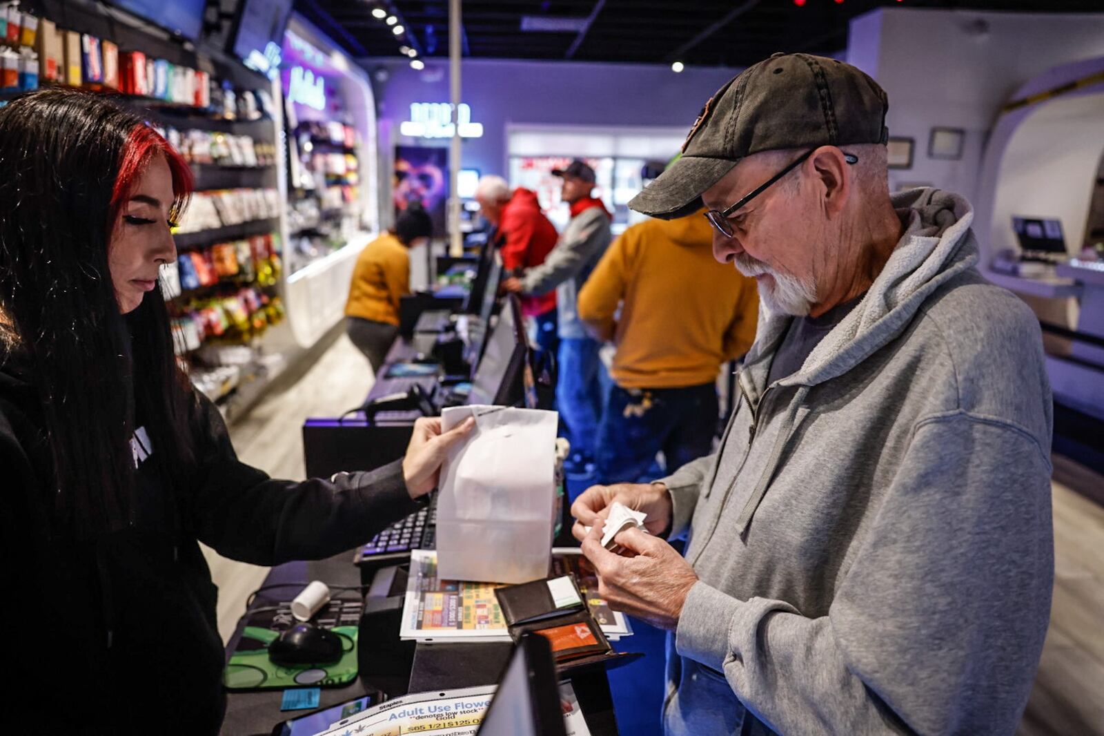 A man from near Toledo buys recreational marijuana at Amazing Budz just across the state border in Michigan, where it is legal. JIM NOELKER/STAFF