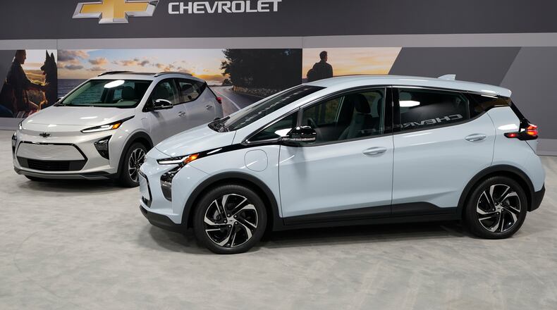 The 2022 Bolt EV, foreground, and EUV are displayed, Thursday, Feb. 11, in Milford, Mich. Whether people want them or not, automakers are rolling out multiple new electric vehicle models as the auto industry responds to stricter pollution regulations worldwide and calls to reduce emissions to fight climate change.  (AP Photo/Carlos Osorio)
