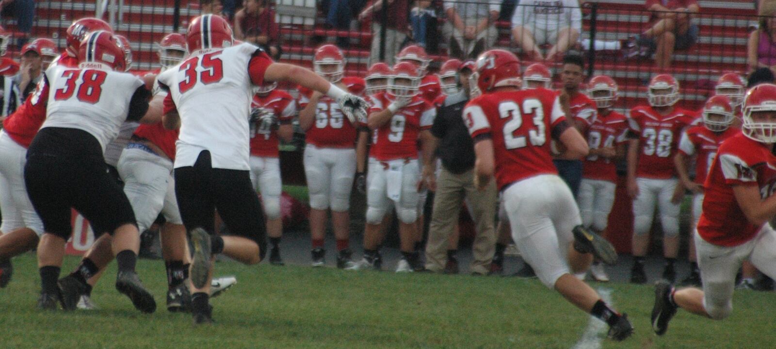 Milton-Union’s Andrew Lambert (23) carries the ball and is pursued by Madison’s Levi McMonigle (35) and Max Evans (38) during Friday night’s game at Memorial Stadium in West Milton. Madison won 34-0. RICK CASSANO/STAFF