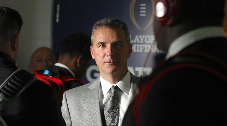 Ohio State’s Urban Meyer greets players as they enter the locker room after arriving at the Fiesta Bowl on Dec. 31, 2016, at University of Phoenix Stadium in Glendale, Ariz. David Jablonski/Staff