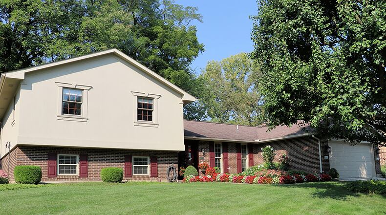 The brick-and-Dryvit house offers 3 bedrooms, 2 full baths and about 2,390 sq. ft. of living space. The irregular-shaped property has a deep park-like back yard with walking paths among the mature trees and perennial gardens. The house has a 2-car, attached garage with a side service door. CONTRIBUTED PHOTO BY KATHY TYLER