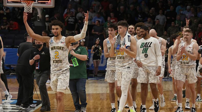 The Wright State Raiders, led by Tanner Holden, march off the court victorious Wednesday, March 16, 2022 after defeating Bryant in the First Four game. BILL LACKEY/STAFF