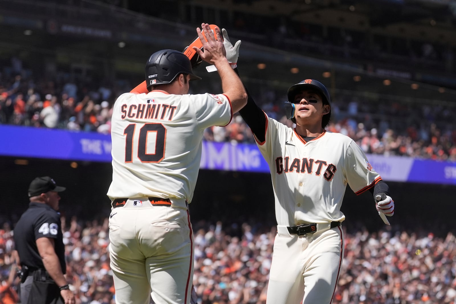 San Francisco Giants' Casey Schmitt (10) celebrates with Jung Hoo Lee after both scored on Wilmer Flores' two-run double during the seventh inning of a baseball game against the Cleveland Guardians in San Francisco, Thursday, June 19, 2025. (AP Photo/Jeff Chiu)