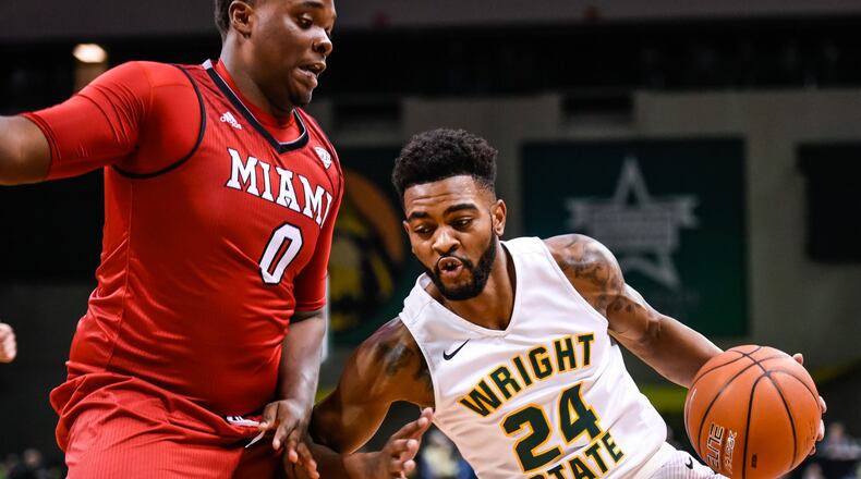 Wright State University’s Mark Alstork dribbles under the hoop defended by Miami University’s Darius Harper during their 89-87 win Miami Tuesday, Nov. 15 at Wright State University’s Nutter Center in Fairborn. NICK GRAHAM/STAFF