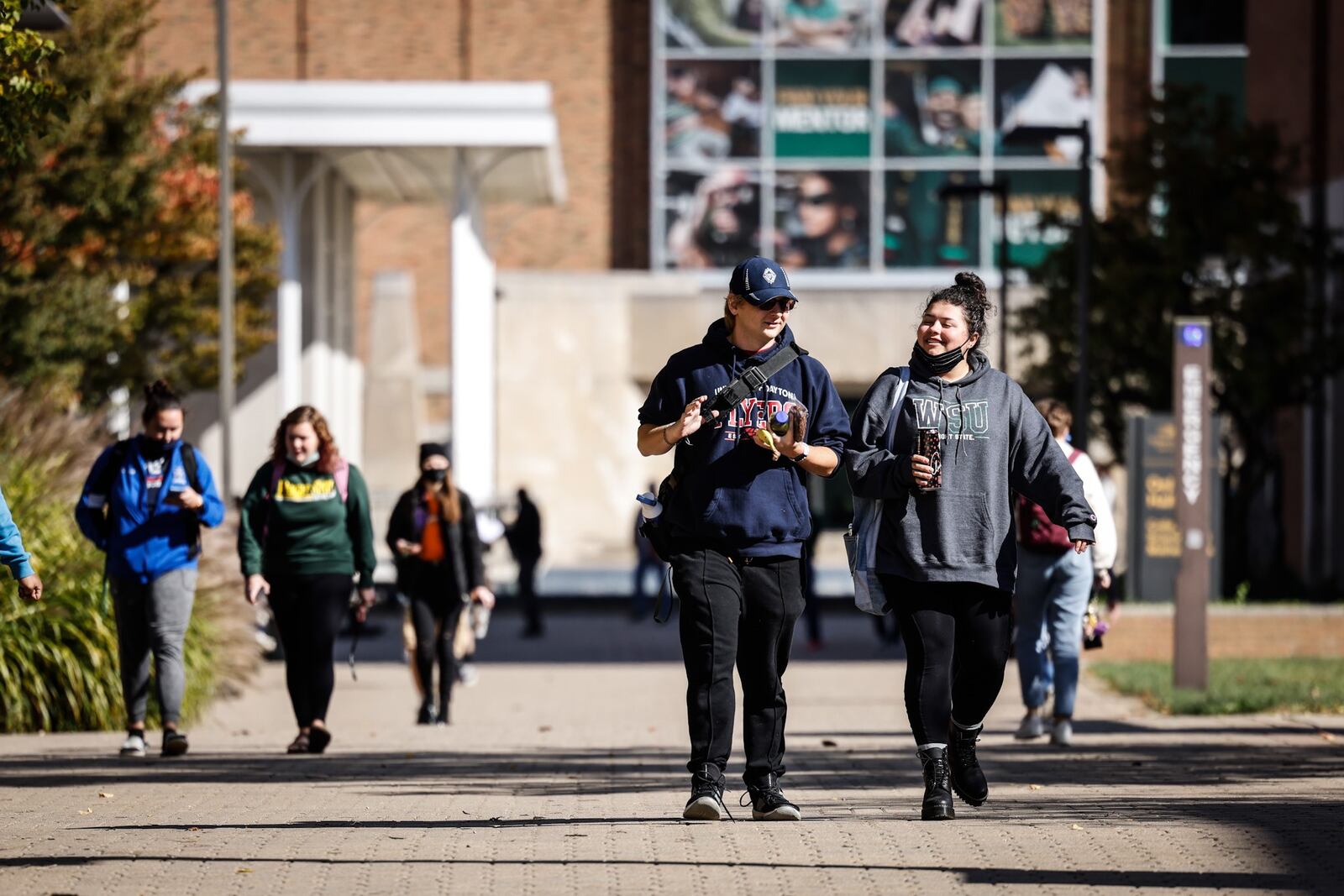 Wright State University students hustle to class Tuesday Oct. 26, 2021. Wright State's enrollment was down slightly this year, However, the university says about 400 more students enrolled this fall than was expected. Wright State has seen enrollment fall for the last several years. JIM NOELKER/STAFF