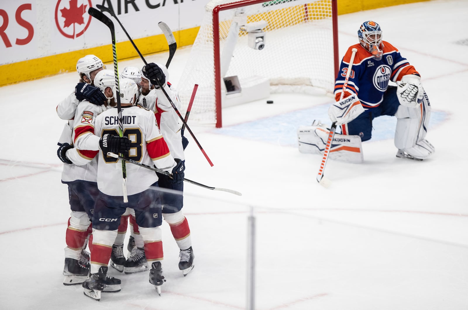 Florida Panthers players, left, celebrate after a goal as Edmonton Oilers' goalie Calvin Pickard (30) looks on during the first period in Game 5 of the NHL hockey Stanley Cup Final in Edmonton, Alberta, Saturday, June 14, 2025. (Jason Franson/The Canadian Press via AP)