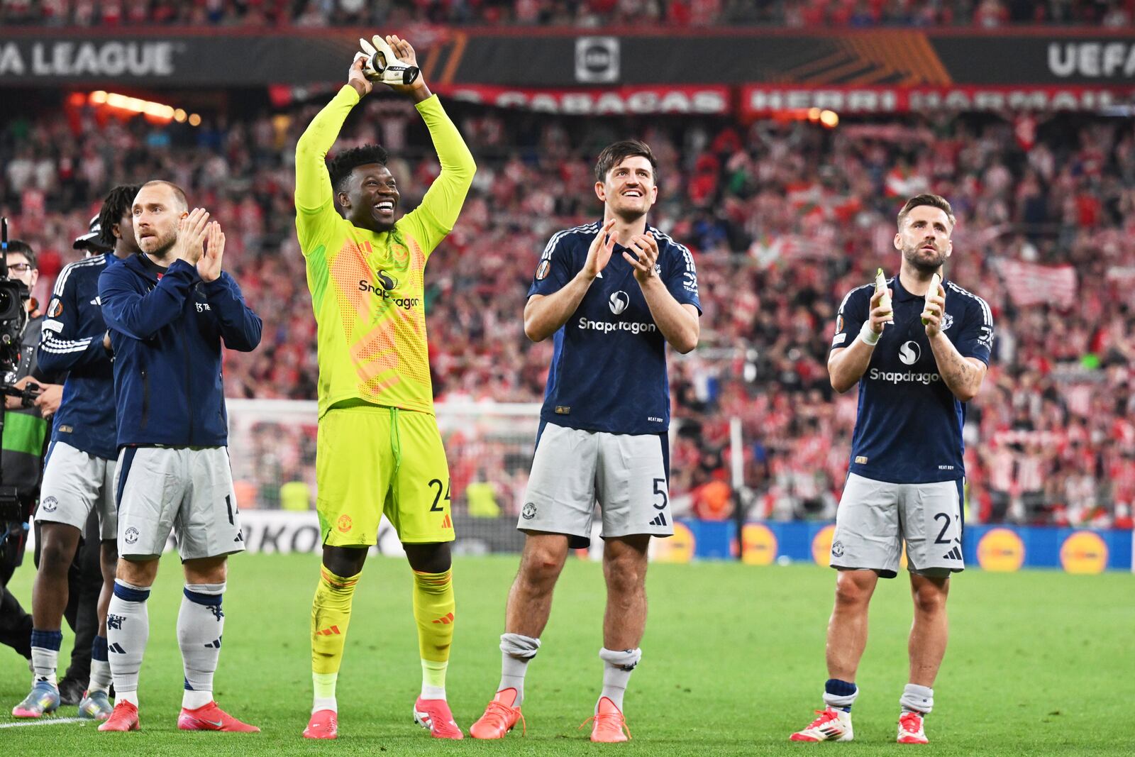 Manchester United's Christian Eriksen, Manchester United's goalkeeper Andre Onana, Manchester United's Harry Maguire, Manchester United's Luke Shaw, from left, celebrate their victory at the Europa League semifinal first leg soccer match between Athletic Bilbao and Manchester United at the San Mames stadium in Bilbao, Spain, Thursday, May 1, 2025. (AP Photo/Miguel Oses)