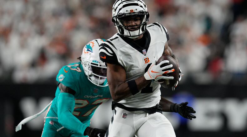 Cincinnati Bengals' Ja'Marr Chase (1) makes a catch against Miami Dolphins' Keion Crossen (27) during the second half of an NFL football game, Thursday, Sept. 29, 2022, in Cincinnati. (AP Photo/Jeff Dean)