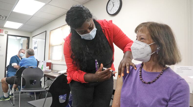 Claudia Fett gets her COVID booster shot Thursday, Sept. 8, 2022 from Ocie Orr, a nurse in the Vaccine Clinic at the Clark County Combined Health District. BILL LACKEY/STAFF