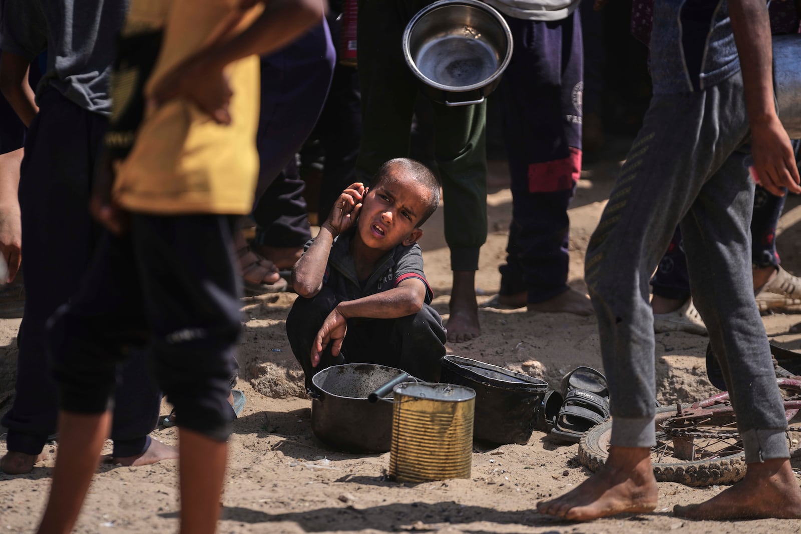 A Palestinian child rests while struggling to obtain donated food at a community kitchen in Khan Younis, in the southern Gaza Strip, Friday, May 9, 2025. (AP Photo/Abdel Kareem Hana)