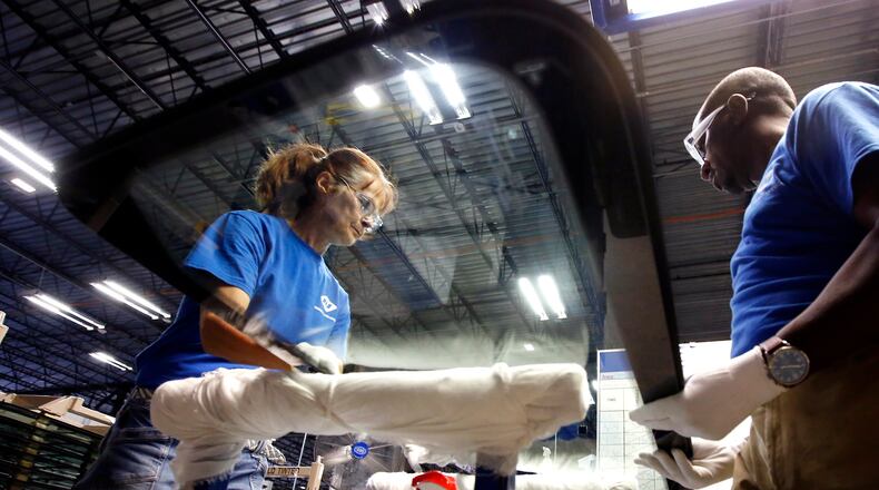 Workers at Fuyao Glass America finish an automobile windshield in the Moraine plant. Fuyao currently employs 2,300 workers and expects to need 700 more within three years. TY GREENLEES / STAFF