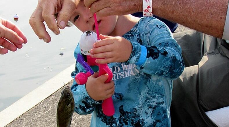 A young boy begins his angling career by landing his first fish - a bluegill. CONTRIBUTED