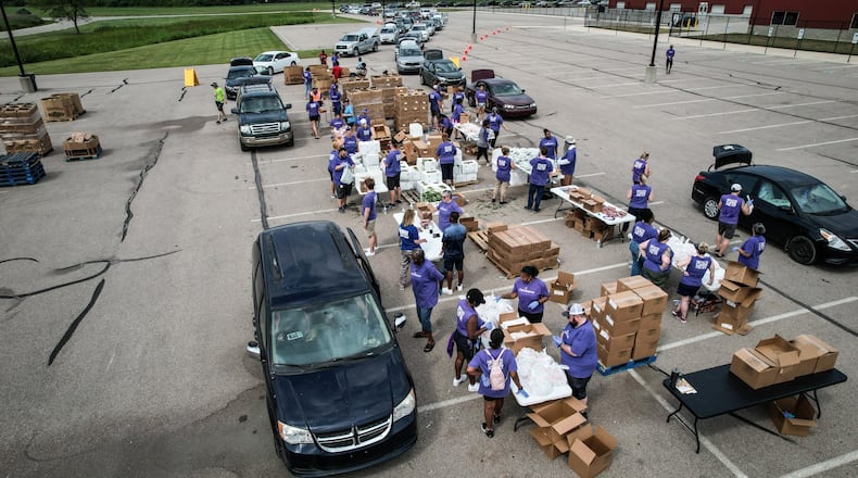 Foodbank and CareSource hosted a mini food distribution at the Montgomery County Fairground Thursday June 20, 2024. Over 600 families registered and the Dayton Flyers basketball team helped with the distribution. JIM NOELKER/STAFF