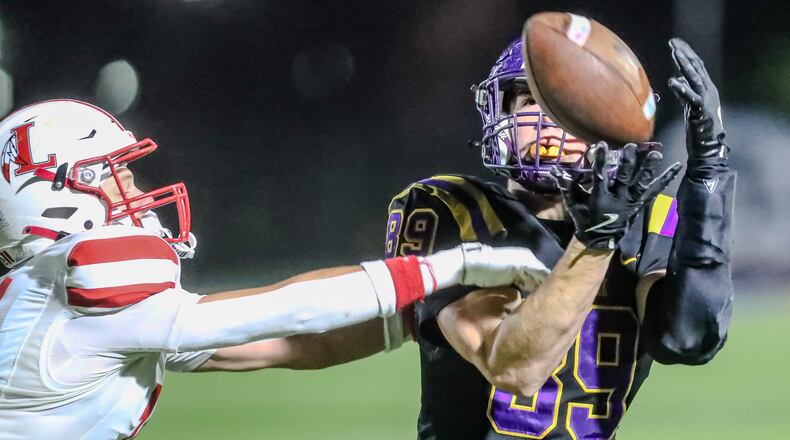 Bellbrook High School senior Jude Omiatek catches a pass along the sideline during their game against London on Friday night at Springfield High School. The Red Raiders won 13-0. CONTRIBUTED PHOTO BY MICHAEL COOPER