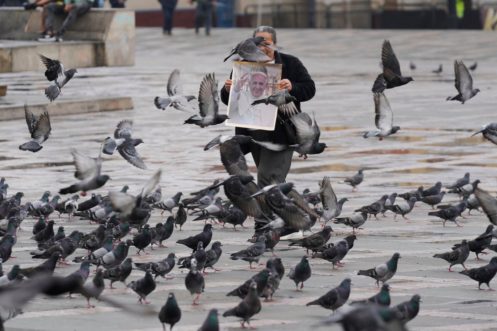 Ana Diaz sells posters of the late Pope Francis near the Cathedral in Bogota, Colombia, Saturday, April 26, 2025. (AP Photo/Fernando Vergara)