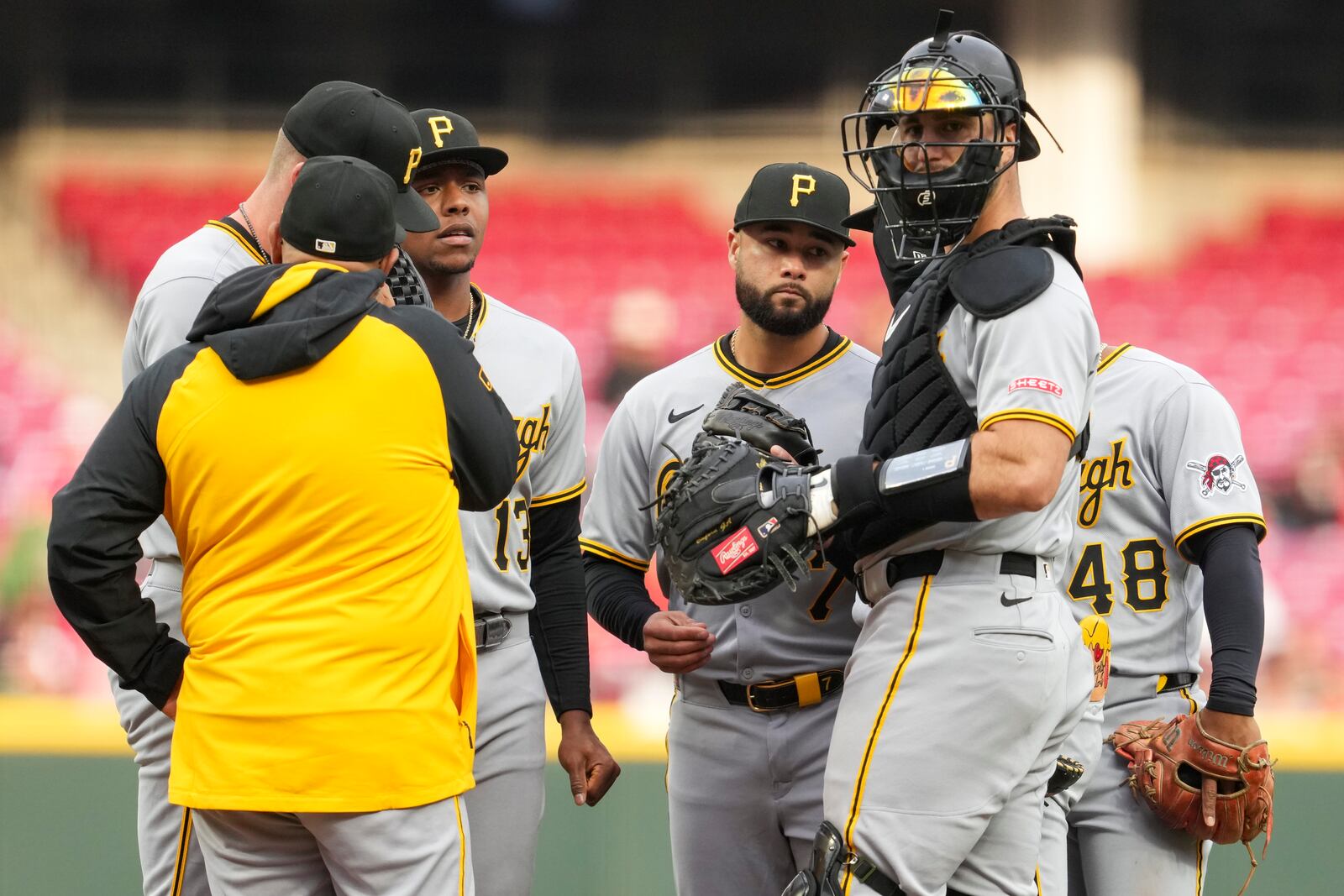 Pittsburgh Pirates players gather at the pitcher's mound during the first inning of a baseball game against the Cincinnati Reds, Friday, April 11, 2025, in Cincinnati. (AP Photo/Jeff Dean)