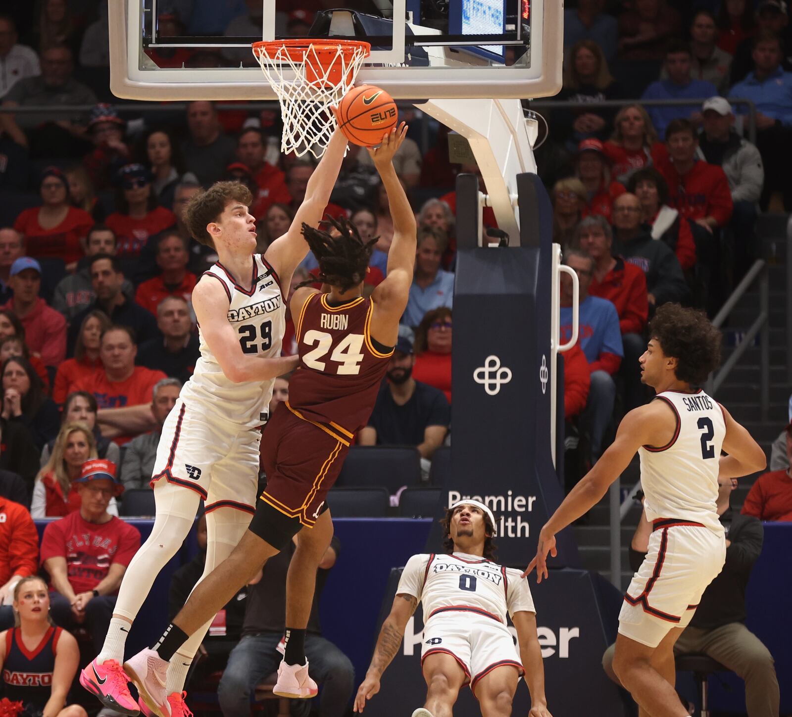 Dayton's Amaël L'Etang, left, blocks a shot against Loyola Chicago's Miles Rubin as Javon Bennett, center, takes a charge on Saturday, Jan. 18, 2025, at UD Arena. David Jablonski/Staff