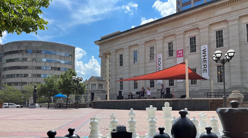 A band performs at lunchtime on Friday on the stage at Courthouse Square as part of the "Square is Where" program. An oversized chess board is one of the games people can play. CORNELIUS FROLIK / STAFF
