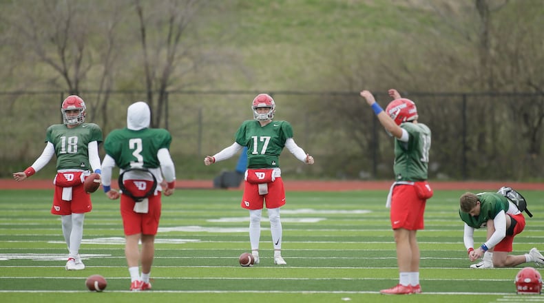 Dayton quarterbacks warm up before practice on Friday, April 1, 2022, at the Jerry Von Mohr Practice Facility. David Jablonski/Staff