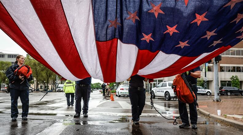 Dayton firefights hoist the flag before the Montgomery County law enforcement Memorial Ceremony at Riverscape Friday morning. Jim Noelker/Staff