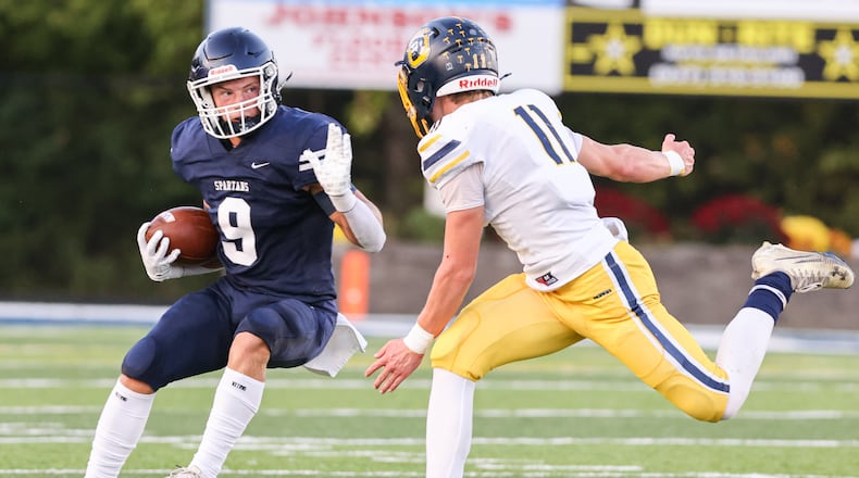 Valley View senior receiver Anthony Valenti runs while trying to avoid Oakwood's Brady Thobe during a Southwestern Buckeye League game on Friday, Sept. 26 at Niswonger Field. BRYANT BILLING / STAFF