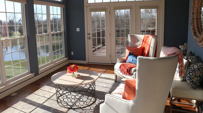 Three walls of windows surround the solarium to bring inside the view of green space, two ponds and a tree line edging the back yard.