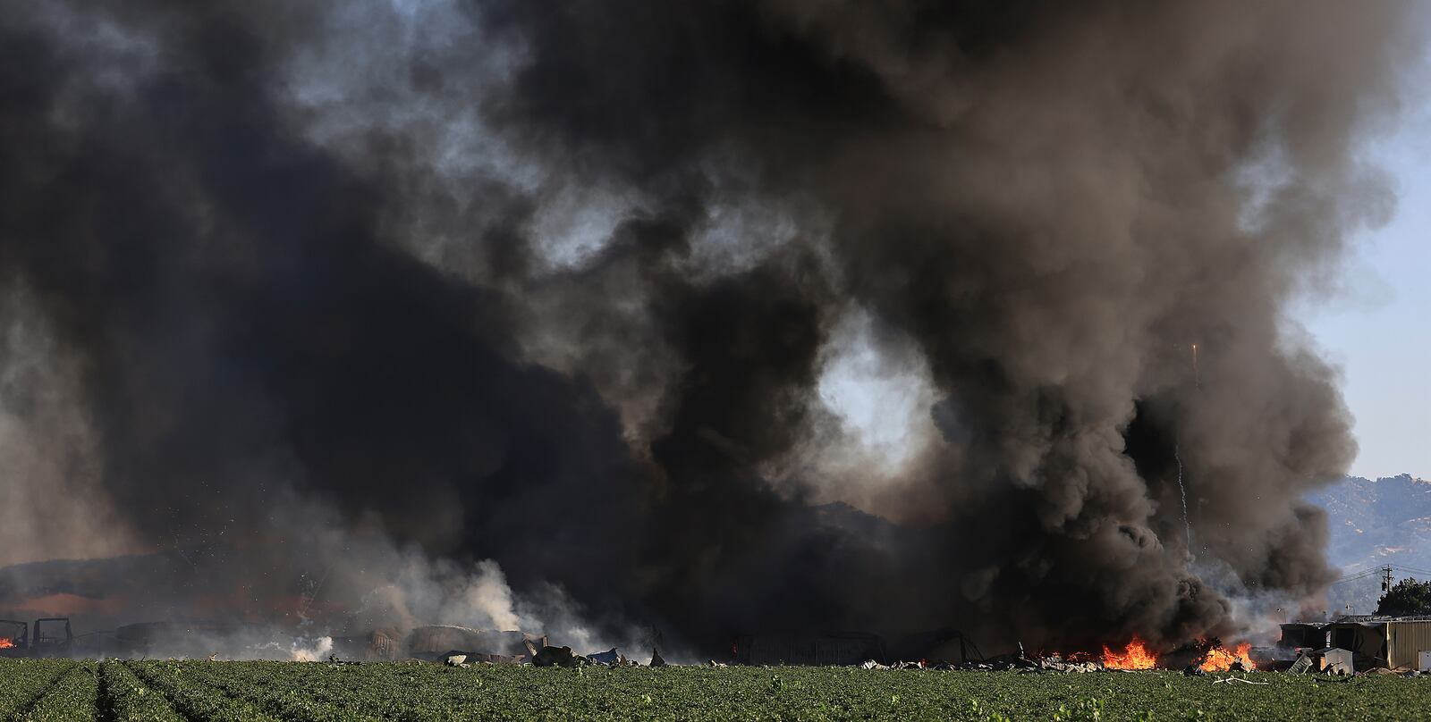 Smoke and flames rise during a fireworks warehouse explosion near Esparto, Calif., Tuesday, July 1, 2025. (Kent Porter/The Press Democrat via AP)