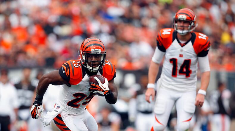 CLEVELAND, OH - SEPTEMBER 29: Half back Giovani Bernard #25 of the Cincinnati Bengals runs the ball as quarterback Andy Dalton #14 looks on against the Cleveland Browns at FirstEnergy Stadium on September 29, 2013 in Cleveland, Ohio. (Photo by Matt Sullivan/Getty Images)