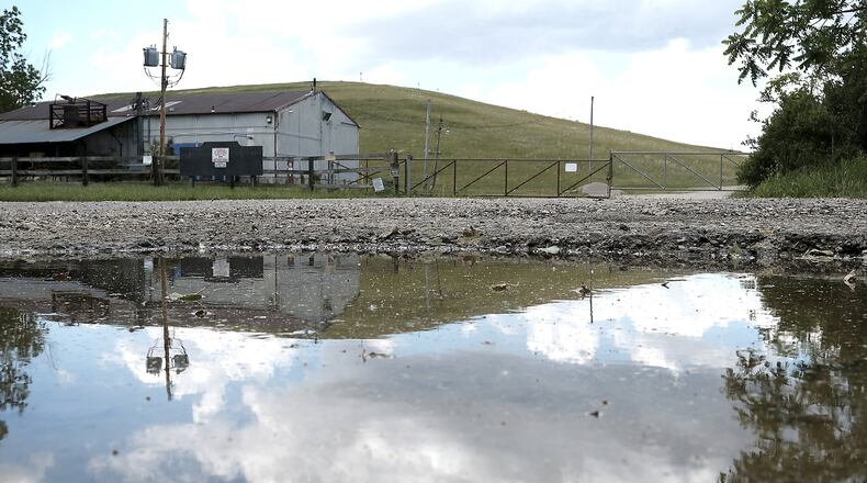 The Tremont City Barrel Fill is reflected in a puddle. There is a current effort to cleanup some of the toxic chemical waste located at the site. Bill Lackey/Staff