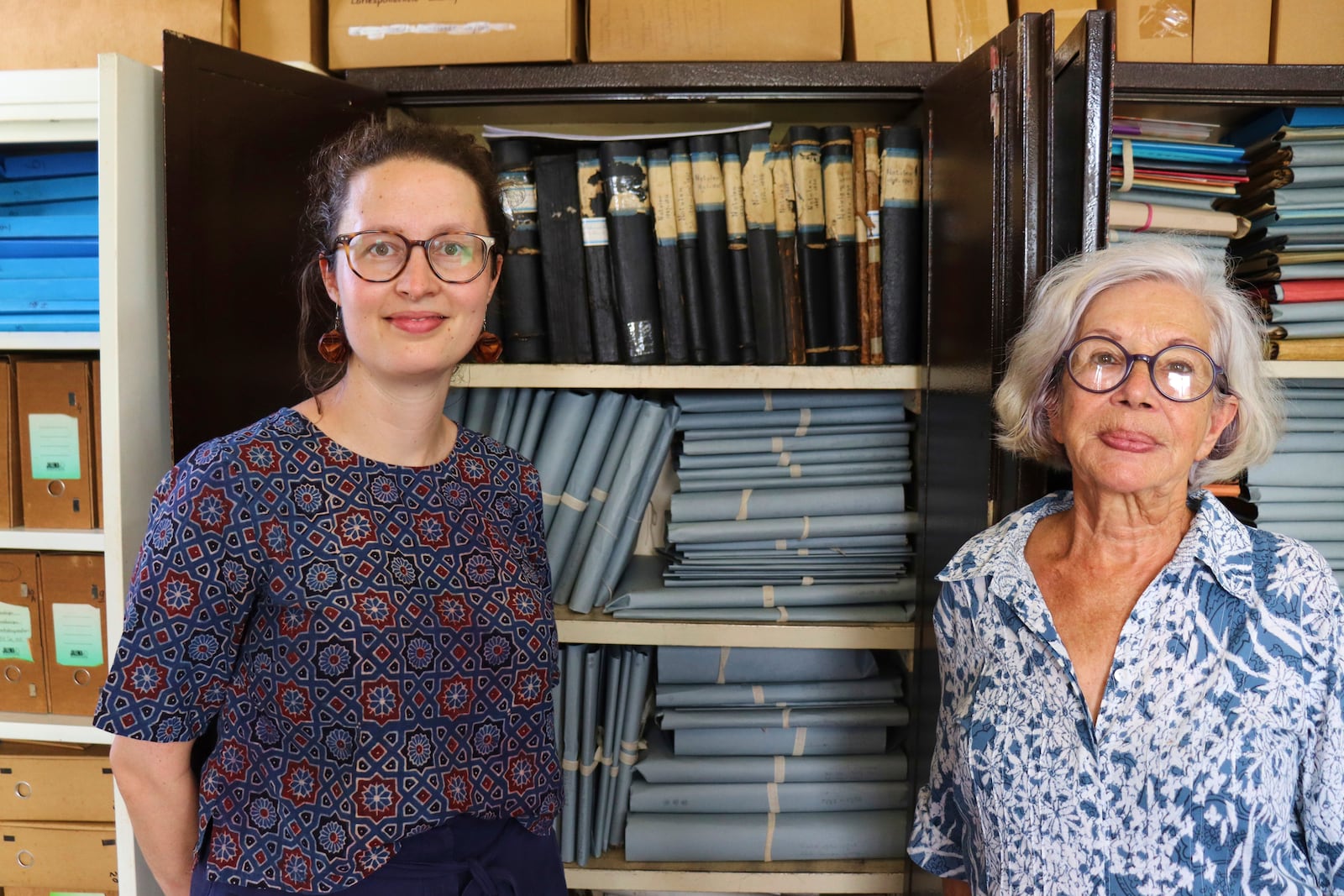 Rosa de Jong, left, and Lilly Duijm pose in front of the boxes of documents from the archive in Paramaribo, Suriname, Friday, May 2, 2025. (AP Photo/Oscar Keur)