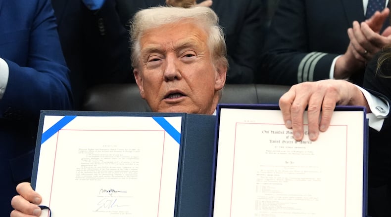 President Donald Trump displays the signed the funding bill to reopen the government, in the Oval Office of the White House, Wednesday, Nov. 12, 2025, in Washington. (AP Photo/Jacquelyn Martin)