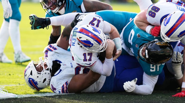 Buffalo Bills quarterback Josh Allen (17) pushes in for a first down as Jacksonville Jaguars defensive tackle Arik Armstead (91) tries to stop him during the second half of an NFL wild-card playoff football game Sunday, Jan. 11, 2026, in Jacksonville, Fla. (AP Photo/Chris O'Meara)