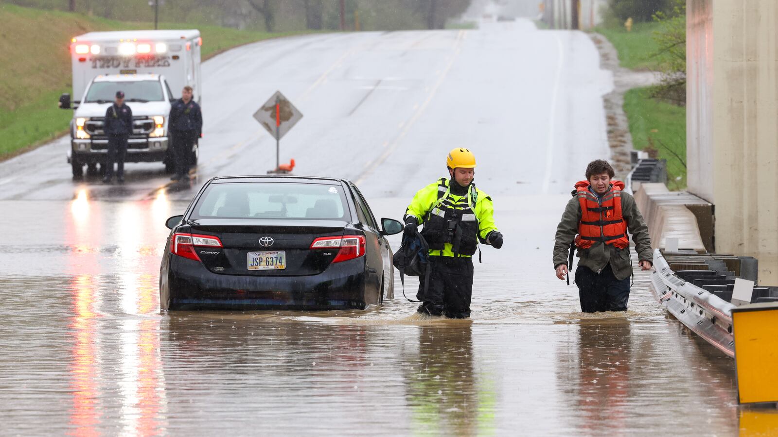 A man walks with a Troy firefighter out of high water on Eldean Road just off of North County Road 25A on Saturday afternoon. The man drove passed high water signs underneath a railroad bridge, and his sedan stopped. Miami County Sheriff’s deputies and Troy EMS responded. The firefighter brought him a lifejacket, and both were able to walk to dry ground. Miami County is dealing with some of the worst flooding in the area due to recent rain. BRYANT BILLING/STAFF