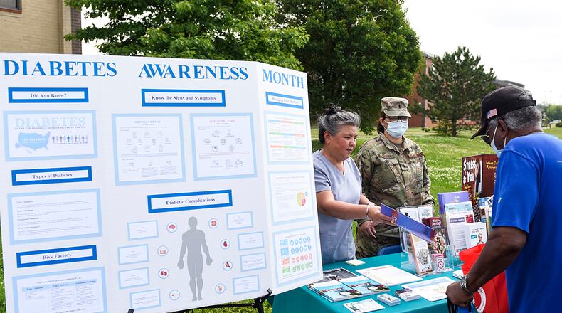 Susie Beard, a disease-management nurse with the 88th Medical Group, hands out informational material during the annual Fit Fest event May 27 at Wright-Patterson Air Force Base. Attendees were able to get information about physical and mental health, as well as participate in competitions. U.S. AIR FORCE PHOTO/WESLEY FARNSWORTH