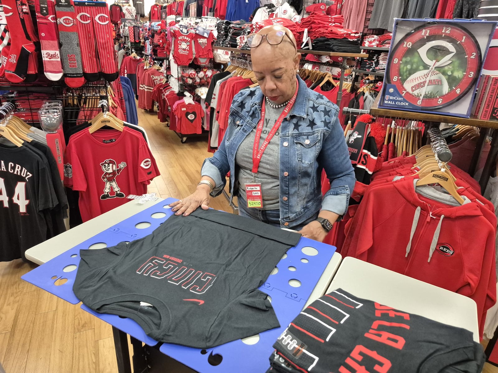Sales associate Roberta Pitman folds merchandise at Rally House Dayton Mall. The store is hiring four positions for the holiday season. MICHAEL KURTZ / STAFF
