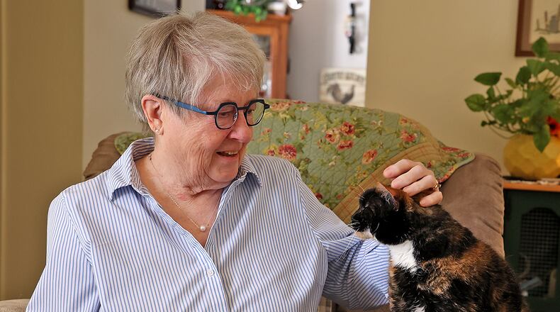 Judy Melvin, who is recovering from a heart attack, pets her cat Tuesday. BILL LACKEY/STAFF