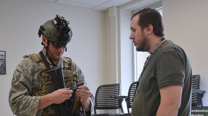 Battle Sight Technologies LLC President Nick Ripplinger (right) shows a member of an Explosive Ordinance Disposal team the Marking Appliance Reusable Chemiluminescence, or MARC, during a Tech Warrior Ops event in Fairborn. The company licensed the technology from the Air Force Research Laboratory Materials and Manufacturing Directorate and demonstrated it at the event. (Contributed photo)