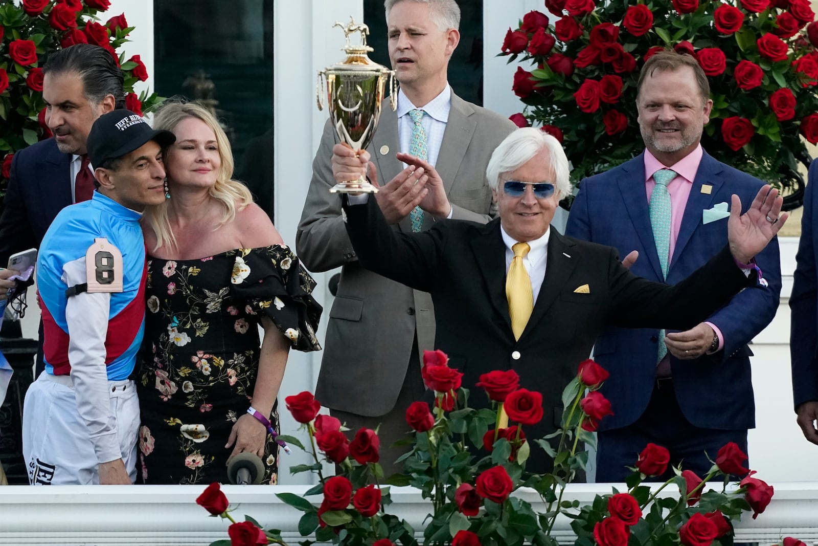 FILE - Jockey John Velazquez, front left, stands with Jill Baffert as they watch as Jill's husband, trainer Bob Baffert, holds up the winner's trophy after Medina Spirit won the 147th running of the Kentucky Derby at Churchill Downs in Louisville, Ky. (AP Photo/Jeff Roberson, File)