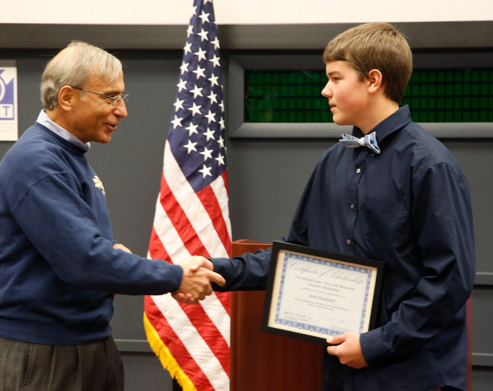 Jay Jabour, left, chairman of Wright B. Flyer Inc., congratulates Alex Hackney, 15, right, who was awarded the annual Mitchell Cary-Don Gum Memorial Aviation Scholarship by the National Aviation Heritage Alliance at the 114th Anniversary of powered flight on Wright Memorial Hill.  TY GREENLEES / STAFF