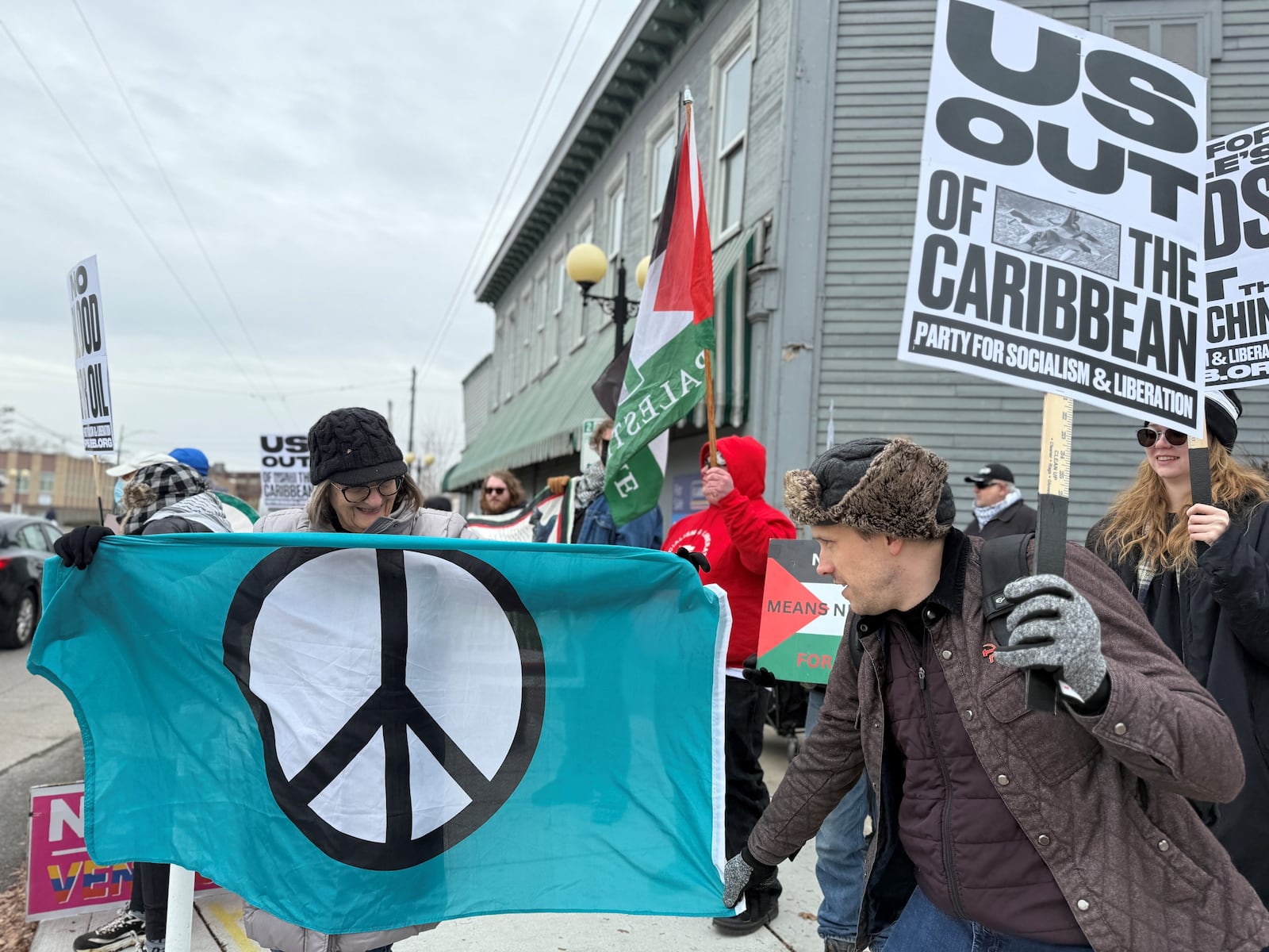 More than 50 people participated in a protest in the Oregon District in downtown Dayton on Saturday to condemn U.S. action against Venezuela. CORNELIUS FROLIK / STAFF