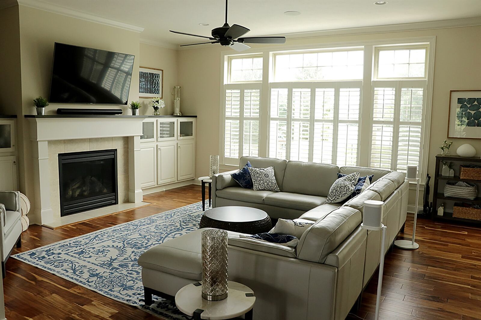 Along one wall of the great room is a gas fireplace flanked by built-in cabinetry with bubble-glass panel doors. Shuttered windows with transoms fill another wall. CONTRIBUTED PHOTO BY KATHY TYLER