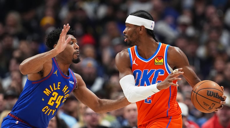 Oklahoma City Thunder guard Shai Gilgeous-Alexander, right, looks to pass the ball as Denver Nuggets guard Jalen Pickett defends in the first half of an NBA basketball game Sunday, Feb. 1, 2026, in Denver. (AP Photo/David Zalubowski)