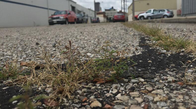 Pond Street, near the 2nd Street Market in the Webster Station neighborhood, has one of the lowest Pavement Condition Index Scores in Dayton. The street, which runs for a block next to a heat treating company, has grass growing out of spots and is coverd in cracks. CORNELIUS FROLIK / STAFF