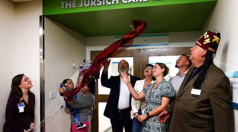 The Jursich family, including Robert Jursich, Jr., his wife, Mary Kay, and daughter and son-in-law, Sarah and Brian Blaine, unveil the newly named Jursich Care Center, which is in the inpatient unit at Shiners Children's Ohio. Robert Jursich, Jr.'s parents, the late Robert Jursich, Sr. and Marthe Jursich, gifted the pediatric burn and specialty care hospital $11.5 million from their estate. The Jursich family was helped by one of the patients, Lucas, who is from Mexico. MARSHALL GORBY\STAFF