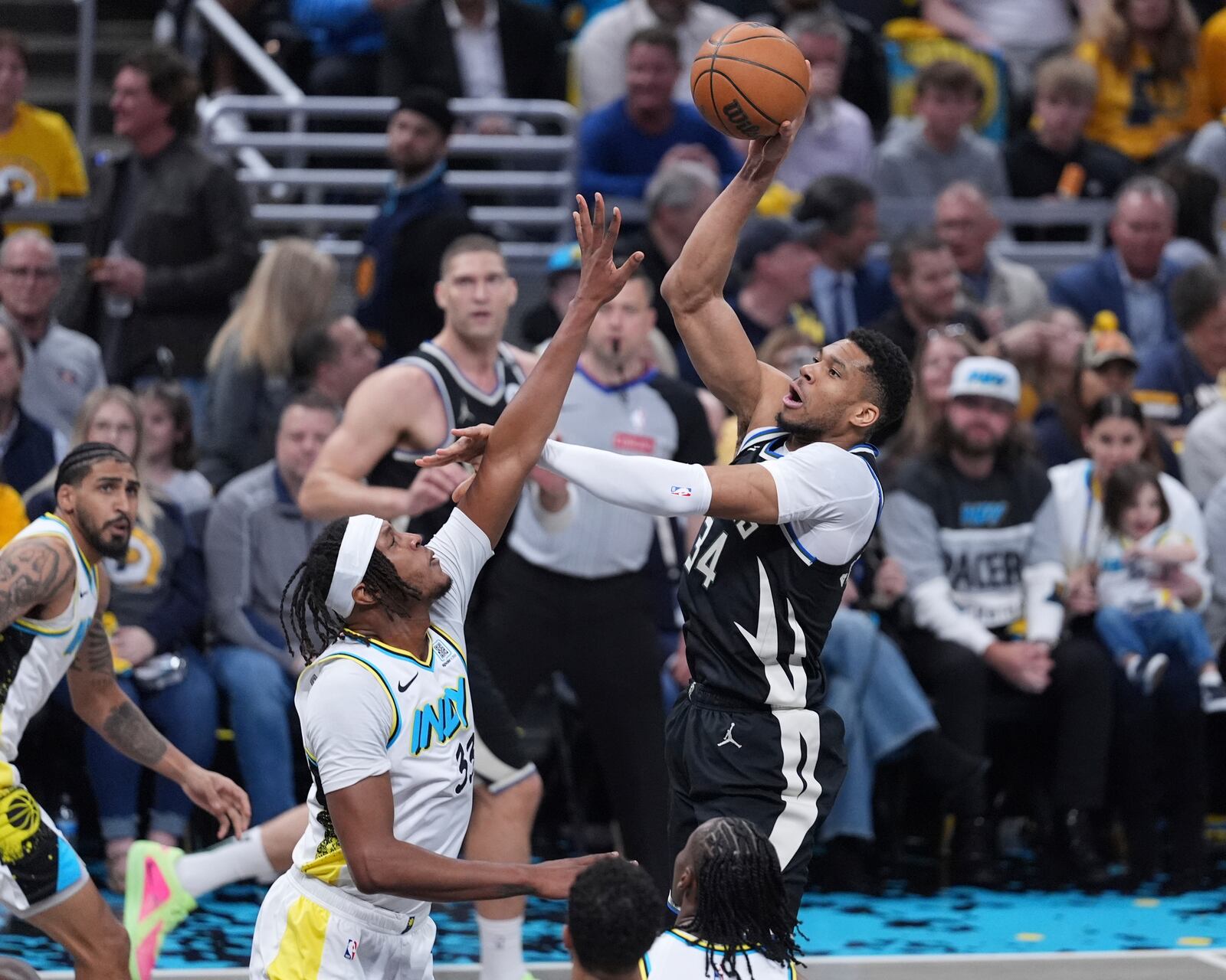 Milwaukee Bucks forward Giannis Antetokounmpo (34) shoots over Indiana Pacers center Myles Turner (33) during the first half of a first-round NBA basketball playoff game in Indianapolis, Tuesday, April 22, 2025. (AP Photo/Michael Conroy)