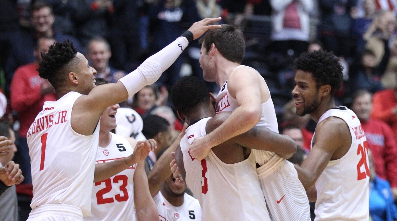 Dayton players congratulate Joey Gruden after he made a 3-pointer in the final minute against Virginia Commonwealth on Friday, Jan. 12, 2018, at UD Arena. David Jablonski/Staff